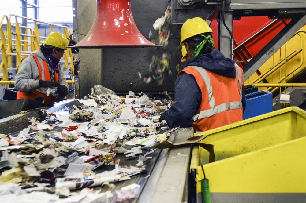Workers from Friedman Recycling separate recyclable material from a conveyor belt that feeds them collected trash. Friedman Recycling receives on average 200 tons of trash each day that require sorting.