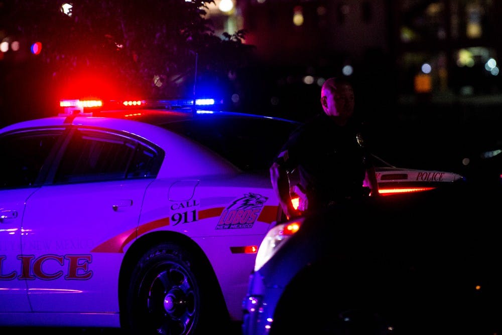 A UNMPD officer stands behind a police cruiser on Sept. 23, 2015.