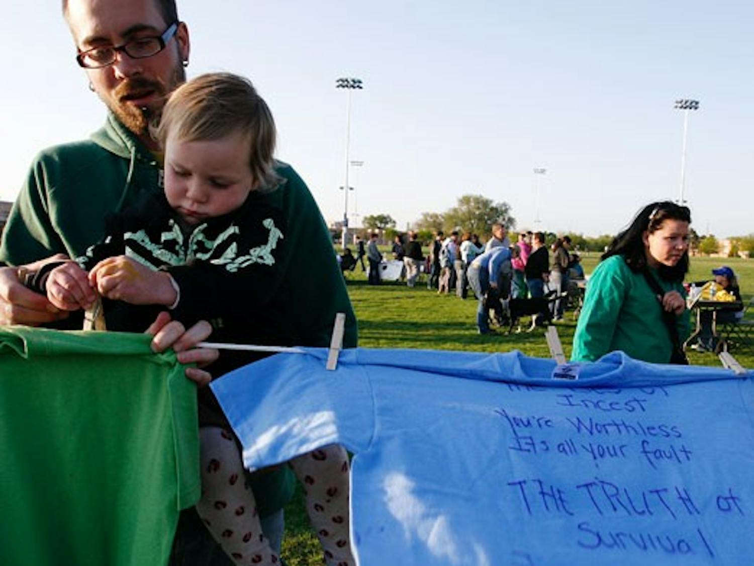Joshua Clair holds his daughter, Isabella LaClair Crowe-Dexter, during Take Back the Night at Johnson Field on Friday.