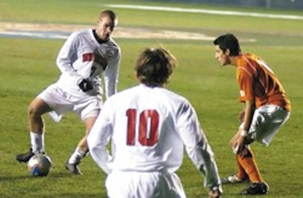 Brandon Moss, left, looks to teammate Lance Watson, center, for a pass during the Lobos' College Cup semifinal victory against Clemson University in Cary, N.C., in December.