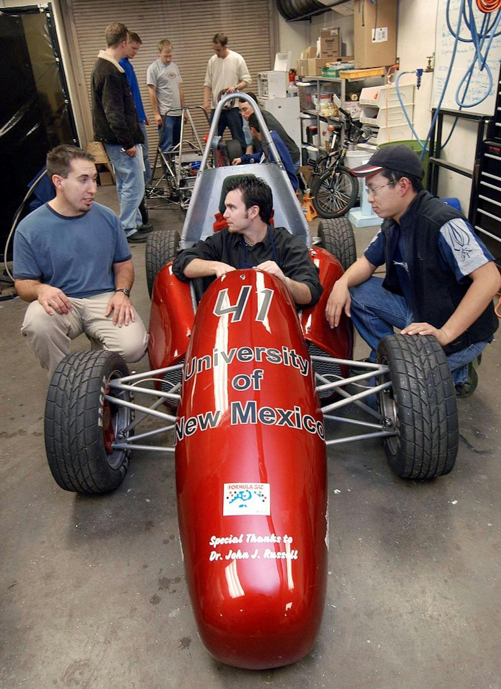 	Members of the UNM Formula Society of Automotive Engineers team surround a race car that they built as part of an international competition.  The Interim Dean of the School of Engineering has not committed to providing the program with $30,000 in funding for 2011.