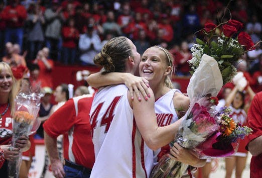 Angela Hartill and Amanda Adamson embrace after the Lobos defeated Wyoming 63-45 on Saturday. Hartill and Adamson were presented with bouquets of flowers on Senior Day.