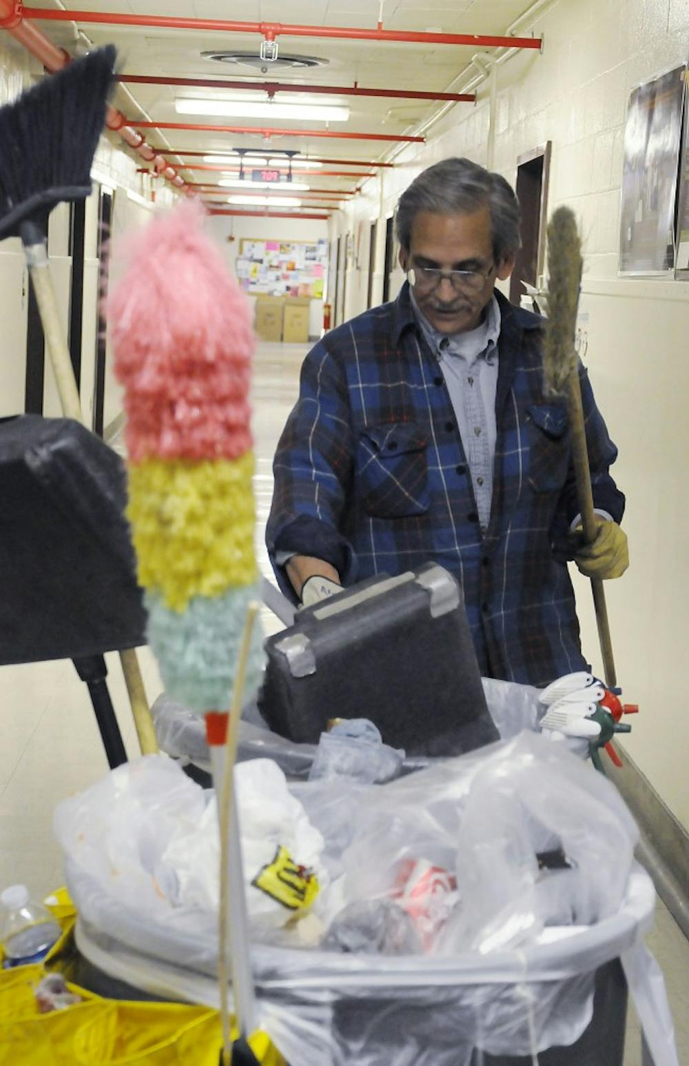 	Phil Aragon wheels his cleaning cart around the halls in the Castetter Hall. Aragon was one of the four custodians given the Luminaria award, which recognizes their commitment to the University.