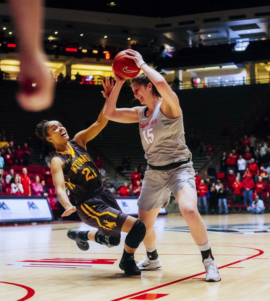 UNM Center Richelle van der Keijl (15) makes hard contact with Woming's Baille Cotton while attempting a layup on Feb 25th at WiesPies Arena