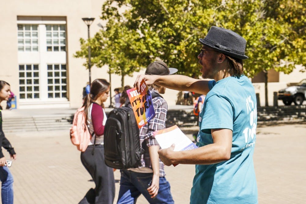 Joey Wrons passes out flyers encouraging students to register to vote for the 2016 elections. NMPIRG, is a non-partisan organization that stands up for the public interest working on the  campaign called the New Voter's Project.