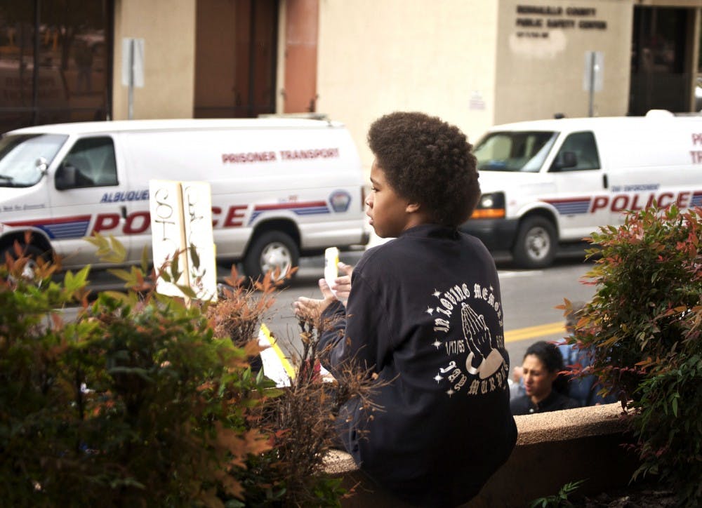 	John Lelei applauds protestors during a rally against police brutality Friday.  Lelei’s stepfather and brother were killed by APD officers on June 5, 2007, and the boy’s T-shirt is in memory of his stepfather.
