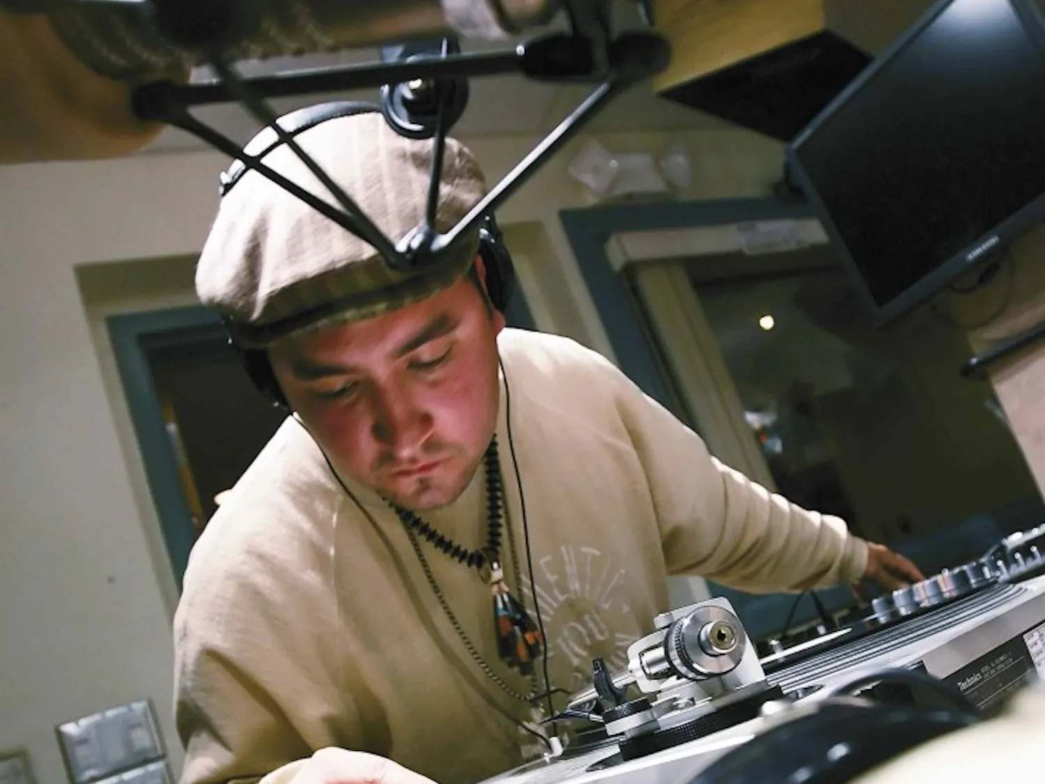 Leon "DJ Badger" Archuleta puts an album on a record player during the hip-hop radio show "Street Beat" at the KUNM studios in O