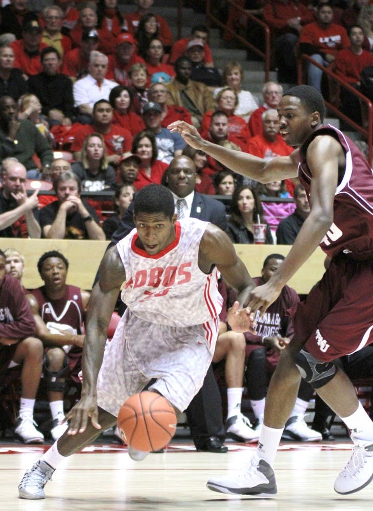 	UNM guard Deshawn Delaney moves around Alabama Bulldog guard Brandon Ellis and up the court during the season opener Saturday at the Pit.