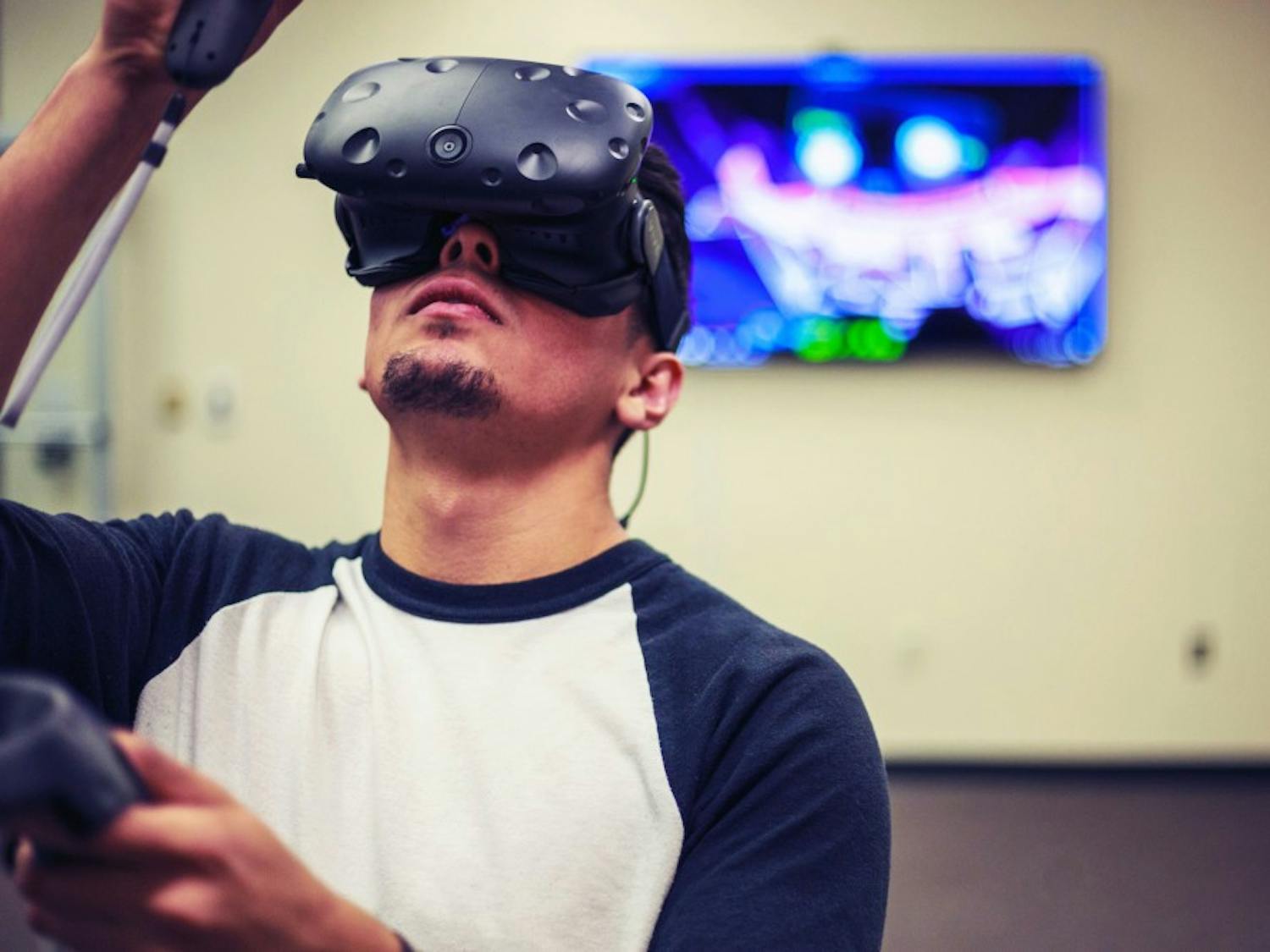 Derek Luna, library technical assistant and junior civil engineering major at UNM, plays a game on the new VR system inside Centennial Library. Luna says that, aside for gaming purposes, he plans to use VR to view his architectural designs.