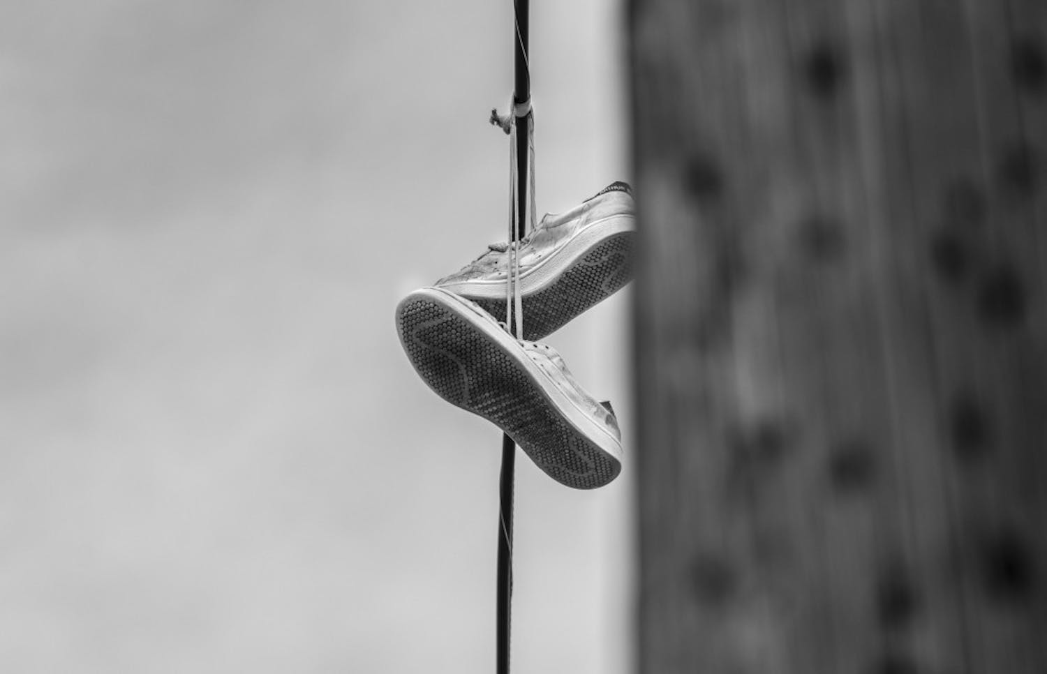 Shoes hang from telephone wires near Downtown Albuquerque. In many inner cities, shoes hanging from telephone wires indicates that a nearby house sells drugs, a problem that plagues the homeless community. People who are homelessness often also experience domestic violence, mental illness, or a combination of these factors.