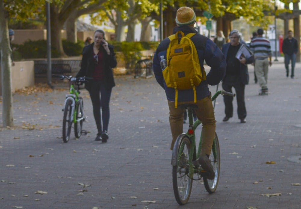 Students take their bicycles onto campus on Oct. 13. UNM was recently awarded a Bronze level recognition for being a Bicycle Friendly Campus.