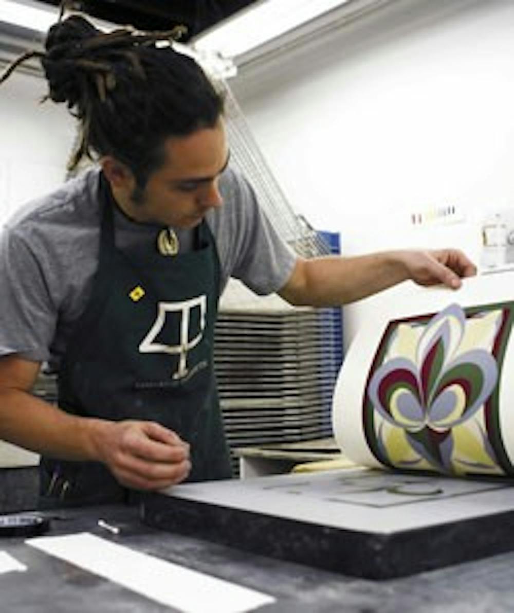 Student Jonathan Goodman pulls a print from an engraved stone Friday at the Tamarind Institute. The institute received $325,000 from Senate Bill 710.