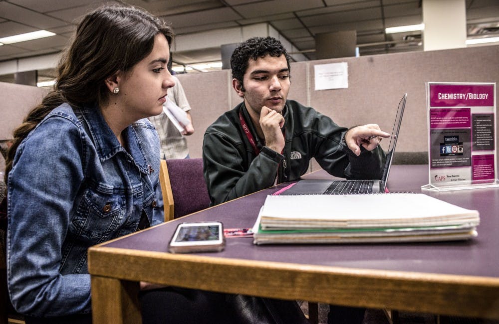 Kaylen Weiss, a dental hygiene student, and Amirali Shokrollahi, STEM tutor with CAPS, go over chemistry homework at the CAPS tutoring center on the third floor of Zimmerman Library, Nov. 3, 2017.