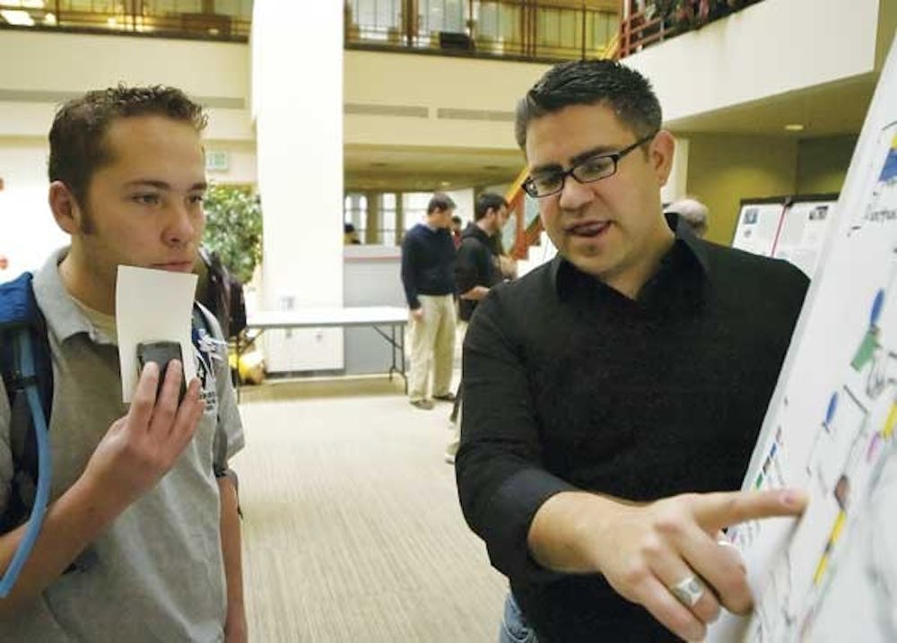 Student Chris Ramirez, right, shows Adrian Carver a map of a proposed redesign of the Cornell Mall made for a Community and Regional Planning class Monday in the SUB.  