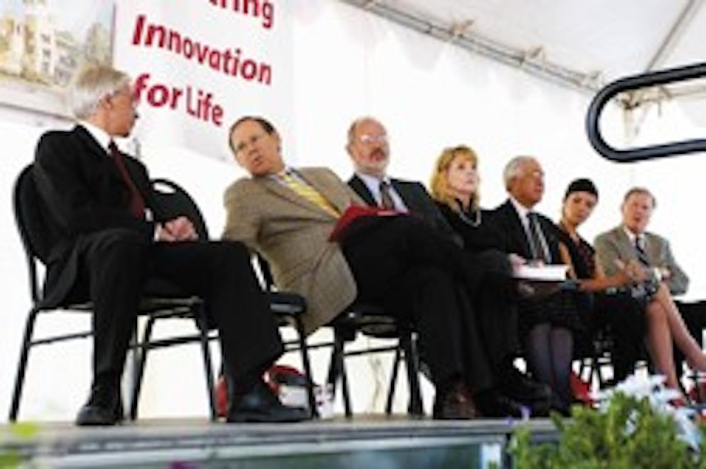 College of Engineering Dean Joseph Cecchi, far left, talks with UNM acting President David Harris before the groundbreaking ceremony for the Centennial Engineering Center on Wednesday. Also on stage, from right, are the center's architect Van Gilbert, ASU