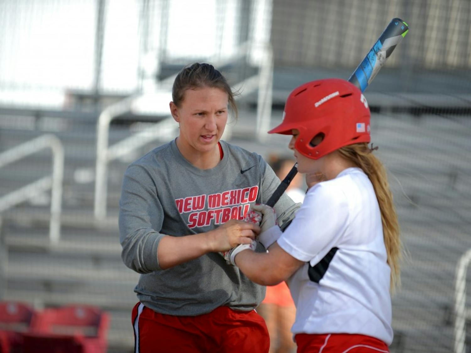 Assistant softball coach Shelby Pendley directs a player on how to grip a bat at the Lobo Softball Field Wednesday afternoon. Pendley, along with Jessica Garcia, are former Lobos hired as coaches following the departure of Lisa-Ann Wallace.