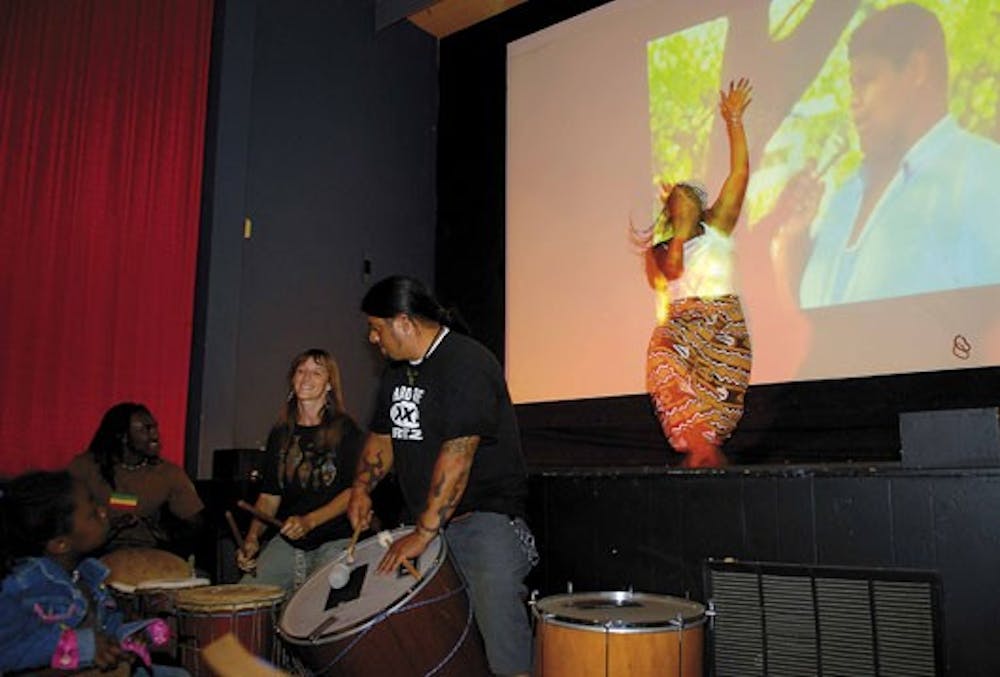 Nia Harris, right, performs an African dance before the screening of "Favela Rising" at the Guild Cinema on Friday. The student group Tercera Raiz, or Third Root, was raising money to bring necessities to Coyolillo, Mexico.