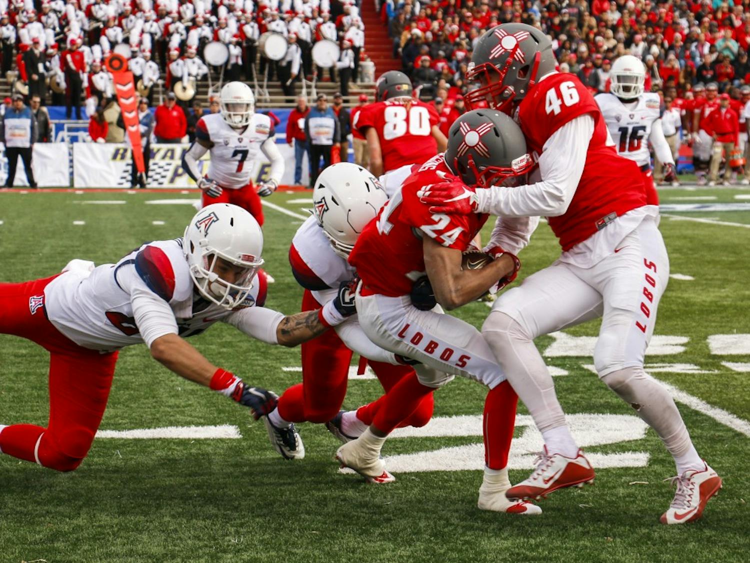 Senior wide receiver Carlos Wiggins (24) is brought down down by Arizona's defense at University Stadium Saturday afternoon. The Lobos lost to the Wild Cats 45-37 in the 10th Gildan New Mexico Bowl.&nbsp;