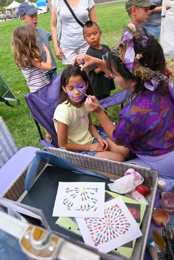 Benita Brennan paints Laticia Romero's face during the Lavender in the Village Festival on July 12 at Los Ranchos de Albuquerque.  