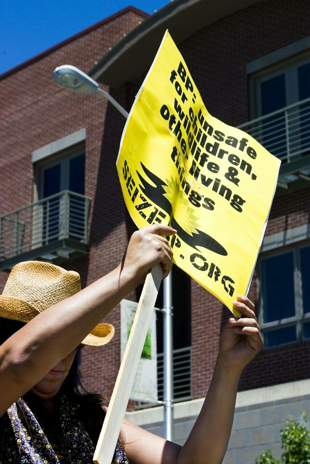 	B.J. Quintana shades herself with her sign during a Seize BP protest on Central Avenue and Tulane Drive on June 5.