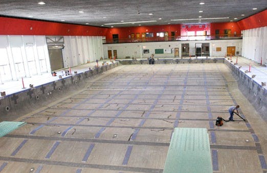 Rex Cameron vacuums the floor of the empty Olympic pool at Johnson Center. The pool was scheduled to open in November after remodeling, but new government regulations require it to have more expensive updates, pushing the reopen date back indefinitely.