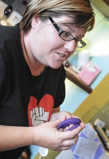 Self Serve co-owner Matie Fricker displays the store's most popular product, the "We Vibe," on July 21. Self Serve offers classes to help patrons to have better, safer sex.