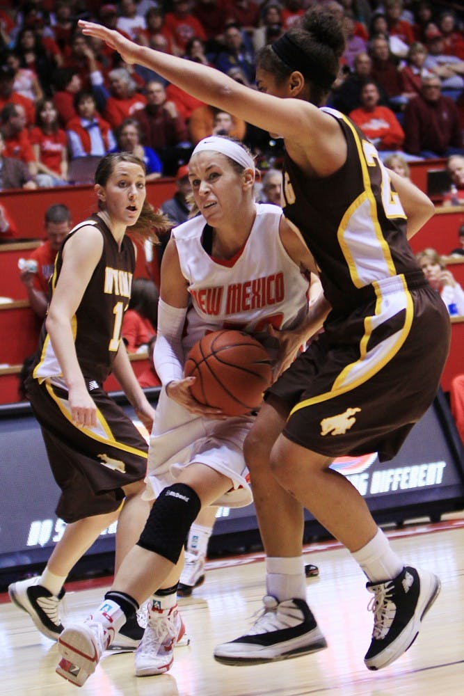 	Amanda Best slices between two Wyoming defenders on the way to the basket during Saturday’s 74-61 win at The Pit. Best had 21 points to lead the Lobos.