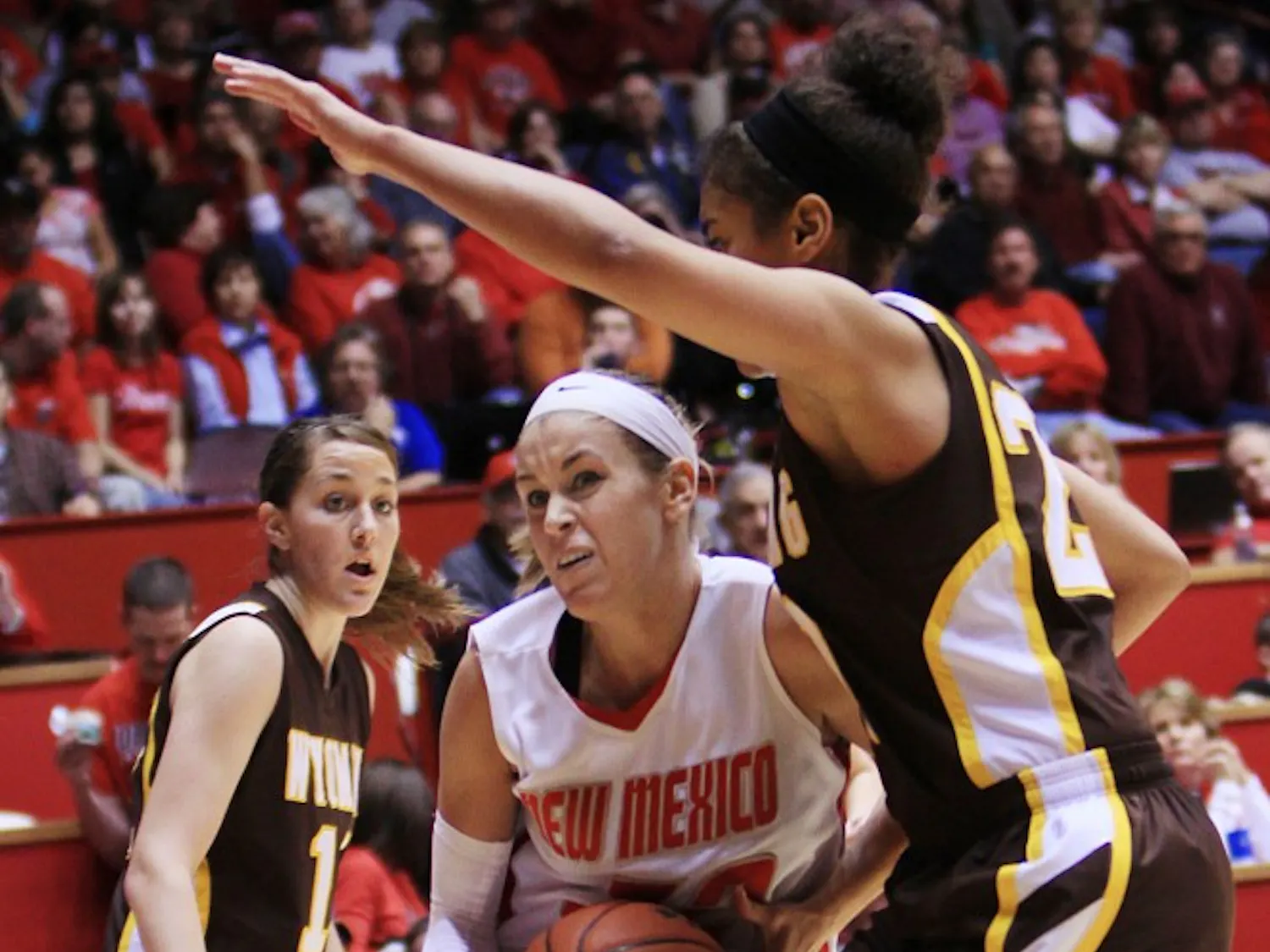 Amanda Best slices between two Wyoming defenders on the way to the basket during Saturday’s 74-61 win at The Pit. Best had 21 points to lead the Lobos.