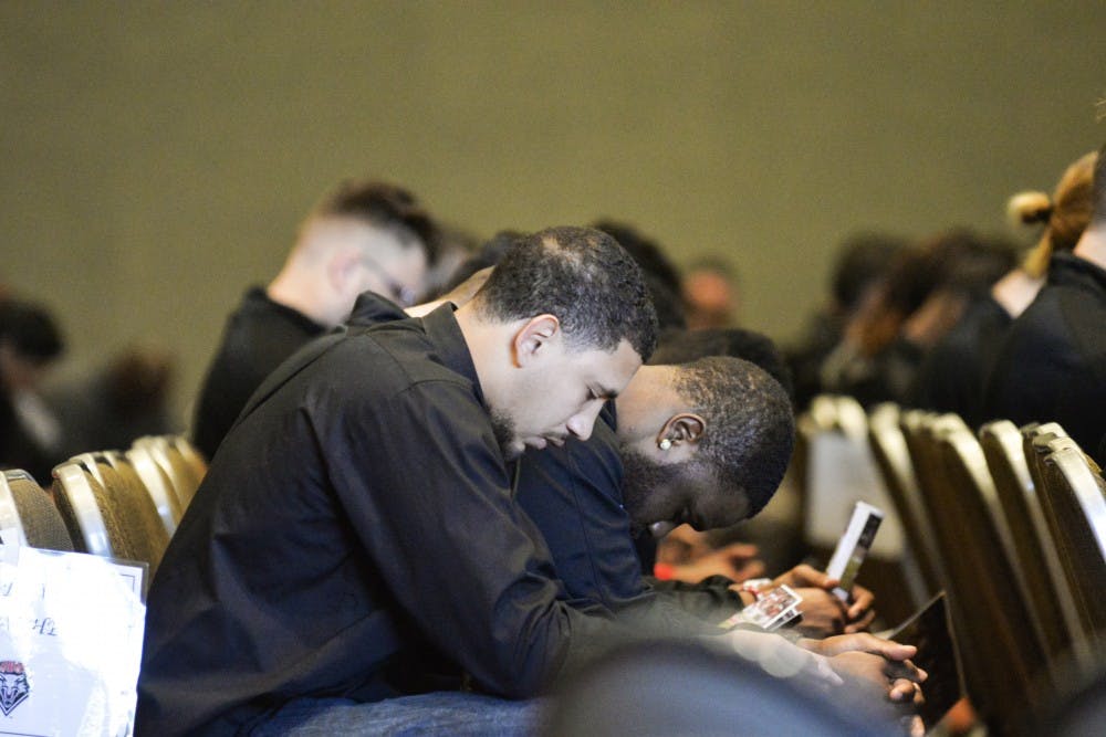 Members of the Lobo football team bow their heads as speakers tell stories of Markel Byrd Sunday afternoon in the SUB Ballroom. Incorporated into the memorial service was an opening prayer and several slideshows featuring Byrd.