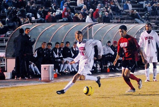 UNM forward Jack Smithson dribbles the ball up field while UNLV forward Lamar Neagle follows during Saturday's game at the UNM Soccer Complex. 