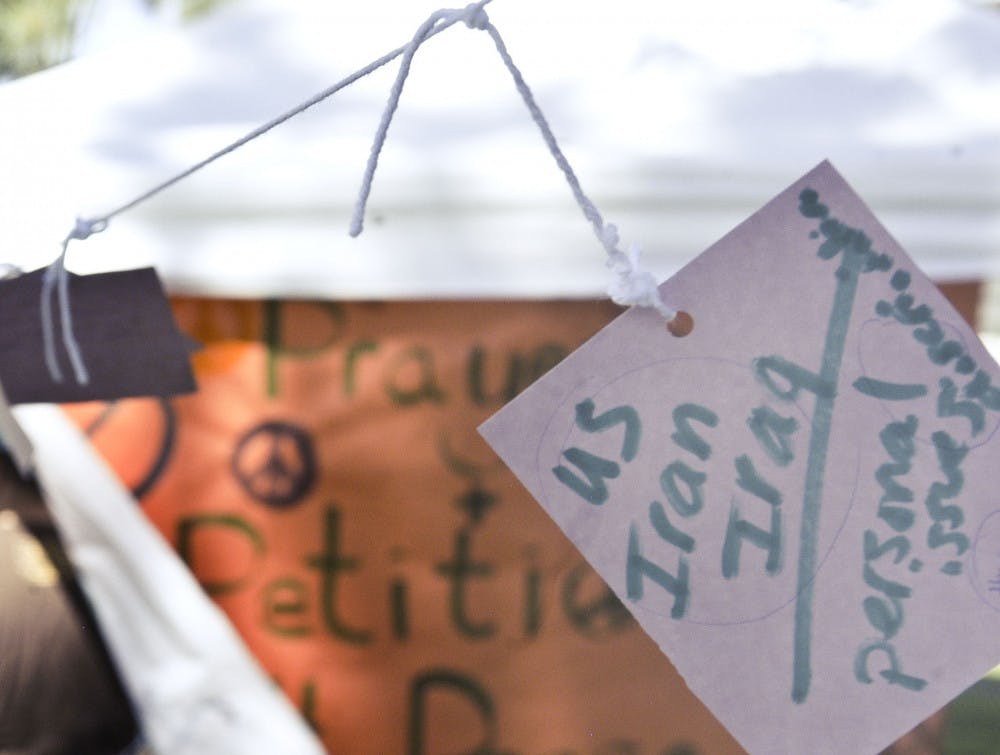 	Handwritten peace wishes hang strung together from a tree on Tuesday near the Duck Pond in celebration of International Day of Prayer for Peace. 