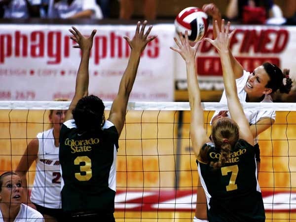UNM outside hitter Jeannie Fairchild spikes the ball while Colorado State defenders Tonya Mokeliki, right, and Mekana Barnes try to block during Saturday's game. The Lobos lost 3-0.