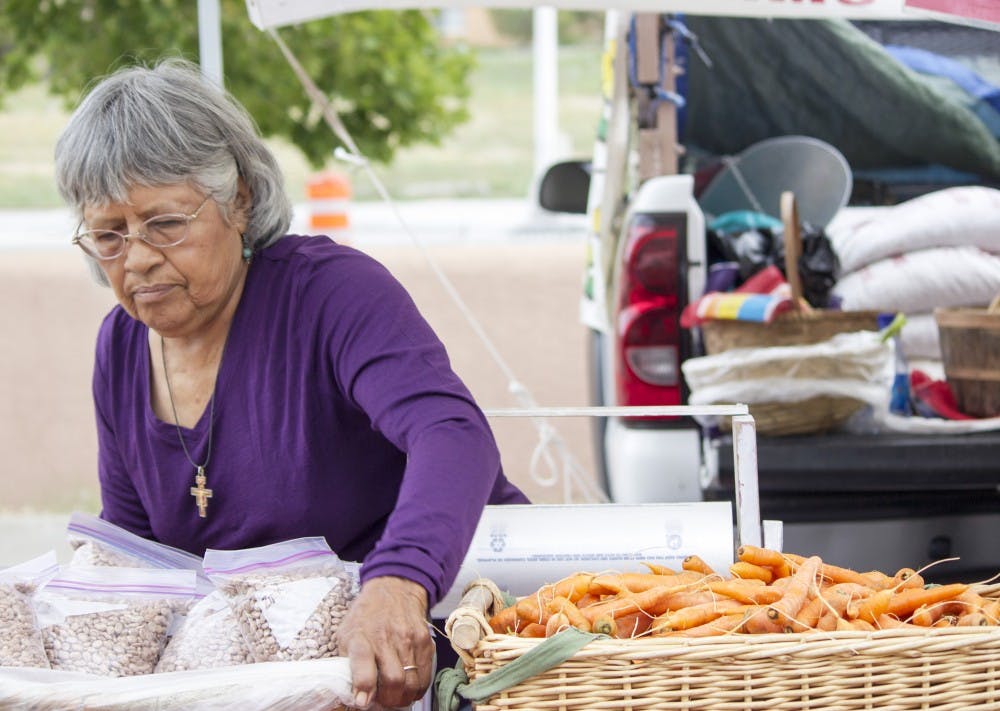 	Mary Macias, a local farmer, sets up her produce early Tuesday morning at the Albuquerque Uptown Grower’s Market, located at Presbyterian Hospital. Macias and other vendors are part of an initiative to foster positive economic relationships between local buyers and farmers by accepting various modes of payments such as WIC, Senior Checks, EBT and Debit.  