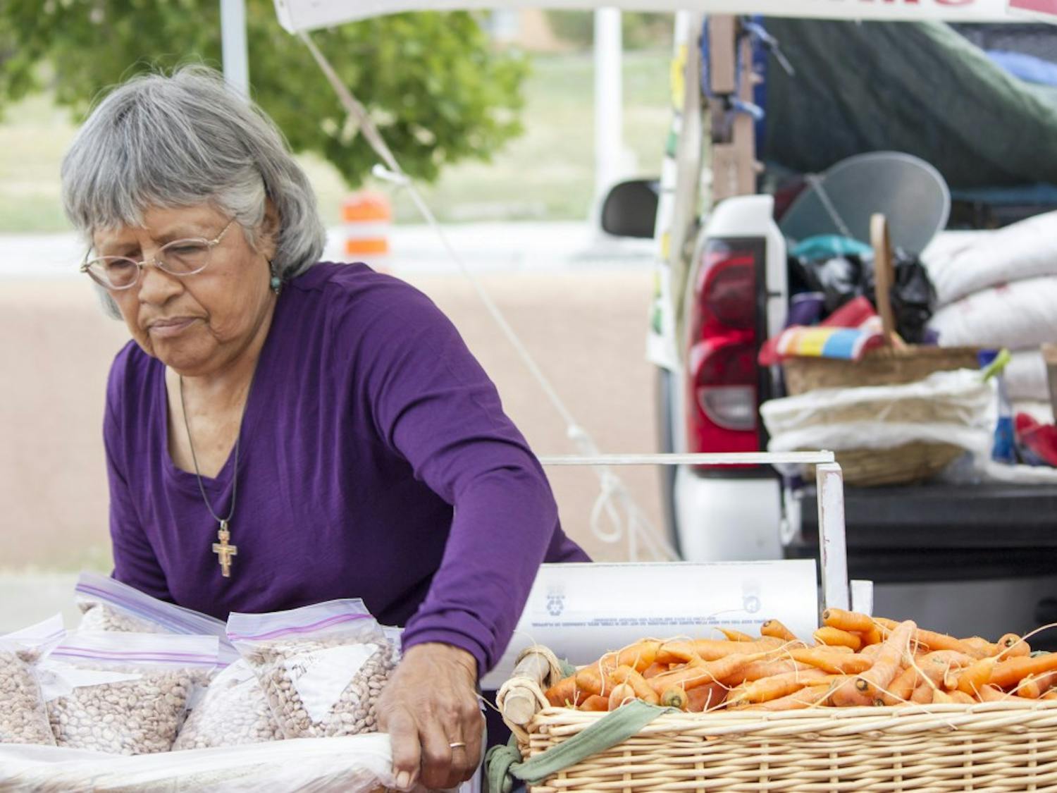 	Mary Macias, a local farmer, sets up her produce early Tuesday morning at the Albuquerque Uptown Grower’s Market, located at Presbyterian Hospital. Macias and other vendors are part of an initiative to foster positive economic relationships between local buyers and farmers by accepting various modes of payments such as WIC, Senior Checks, EBT and Debit.  