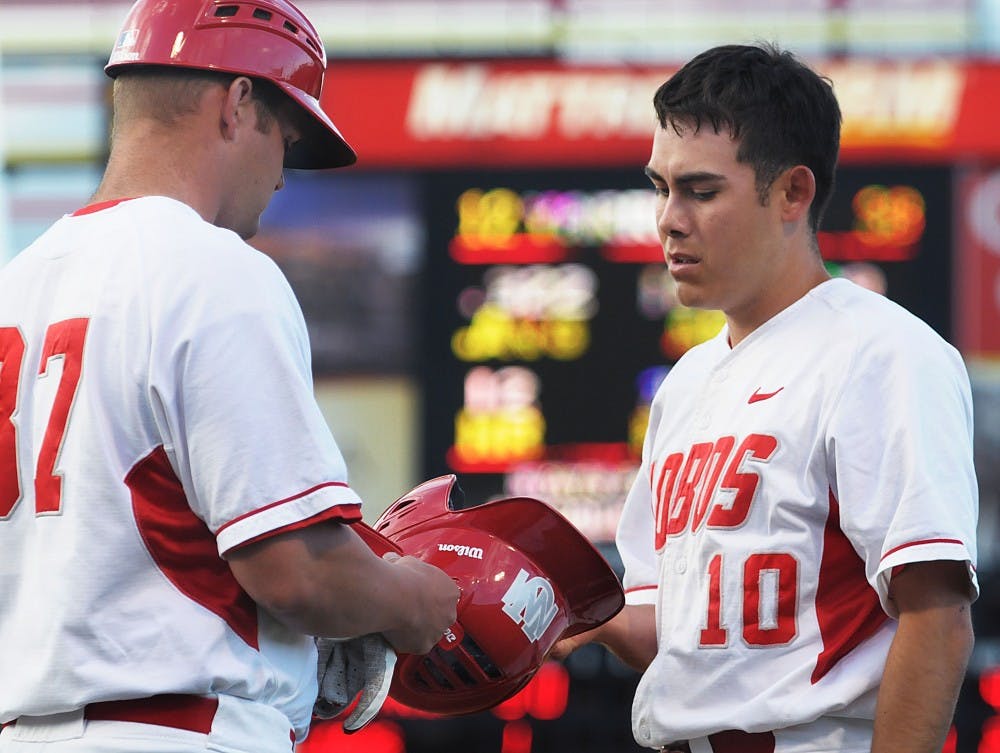 	Daniel Gonzalez gives volunteer assistant coach Clint Stoy his gloves after getting the third out in the bottom of the second inning during Tuesday’s 9-5 loss to San Francisco at Isotopes Park. The Lobos are back in action today at 6 p.m.