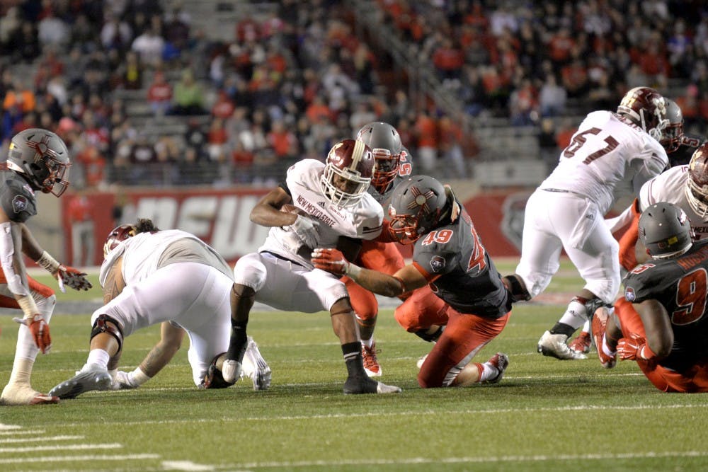 NMSU's Larry Rose III gets taken down by UNM's defensive line during their game Saturday Nov. 3, 2015. New Mexico's defense held Rose III to just 26 rushing yards in the second half.