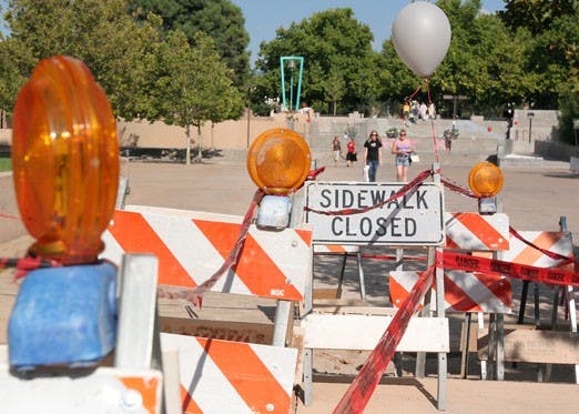 A white balloon from Freshman Family Day decorates construction sidewalk blocks on Smith Plaza. 