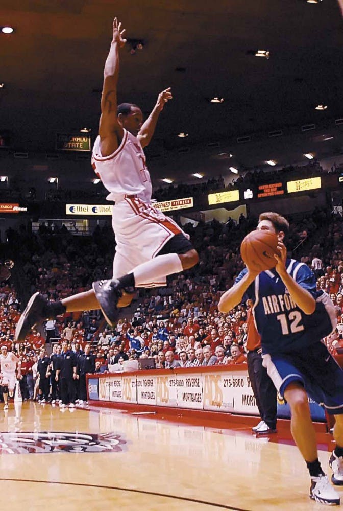UNM guard J.R. Giddens blocks a shot at the buzzer from Air Force guard Tim Anderson at the end of the first half during Saturday's game at The Pit. The Lobos lost 60-51. 