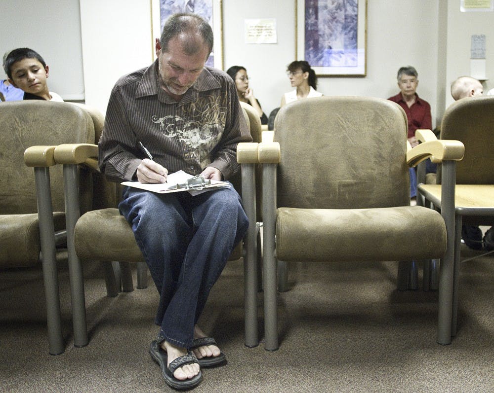 	Gary Small sits in the surgical check-in room and fills the check-in form before going to surgery Wednesday morning. 