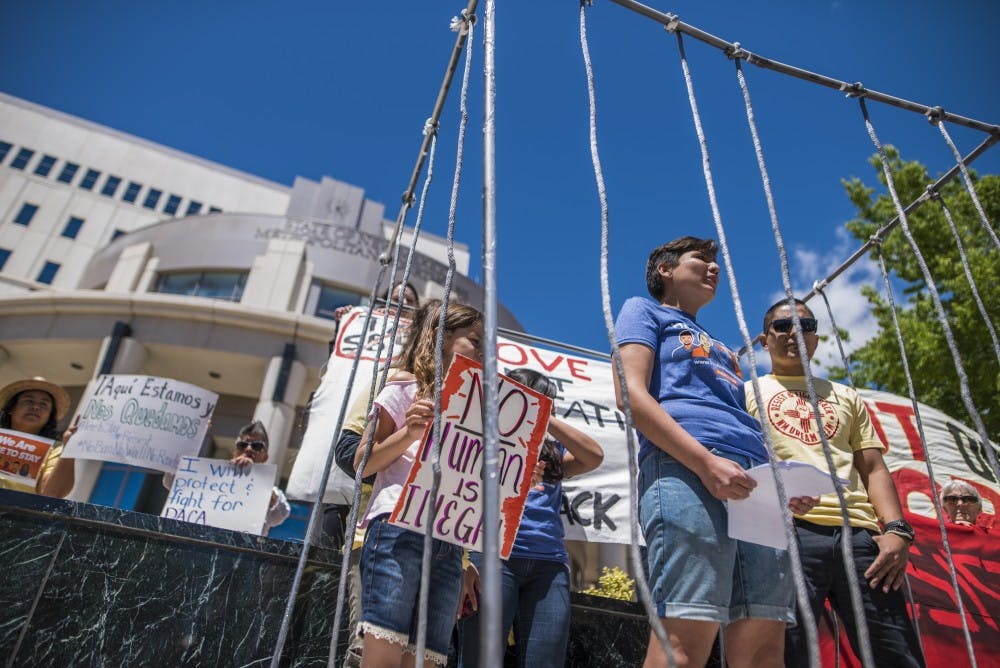 Gabriela Hernandez, center, stands with others in a replicated immigrant detention cell in front of the Metropolitan Courthouse Monday, May 1, 2017. The event was a series of public demonstrations centered around May Day and immigrant and workers rights in the United States.&nbsp;