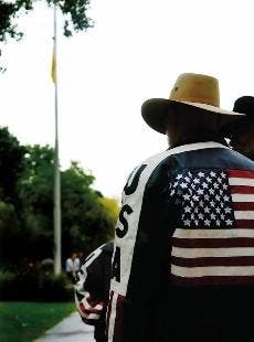 Veteran David Ethridge watches the Mexican flag being raised Thursday in front of Scholes Hall. 