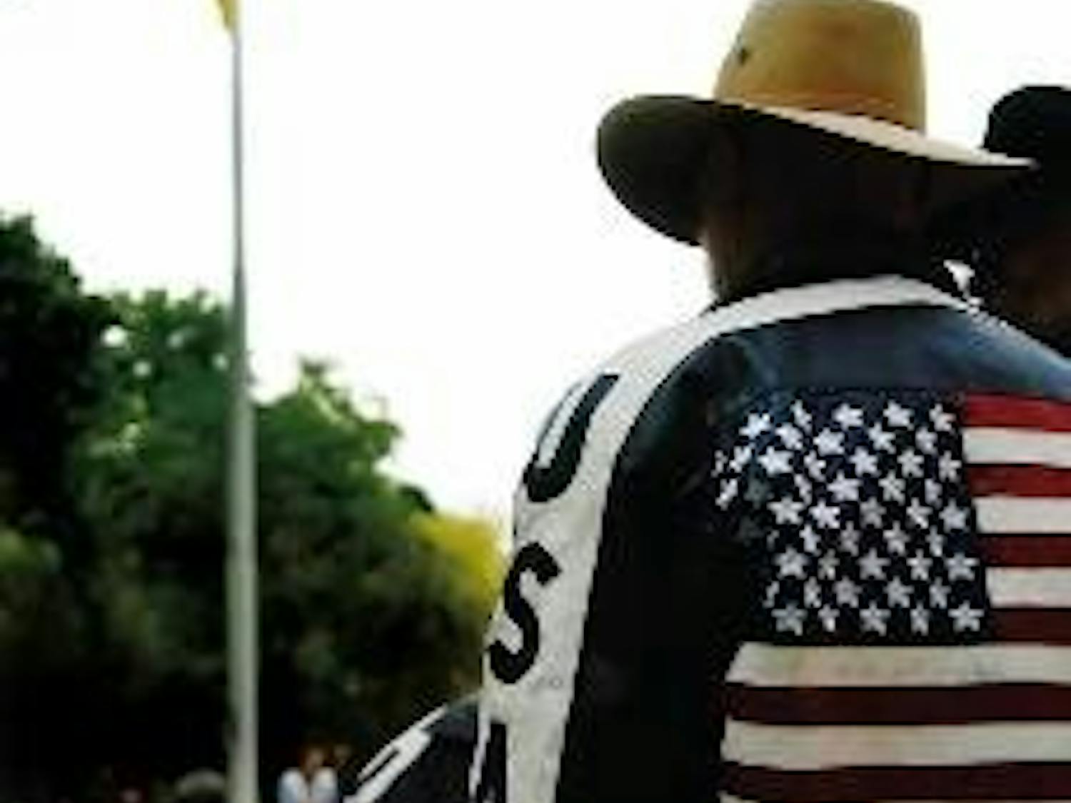 Veteran David Ethridge watches the Mexican flag being raised Thursday in front of Scholes Hall.
