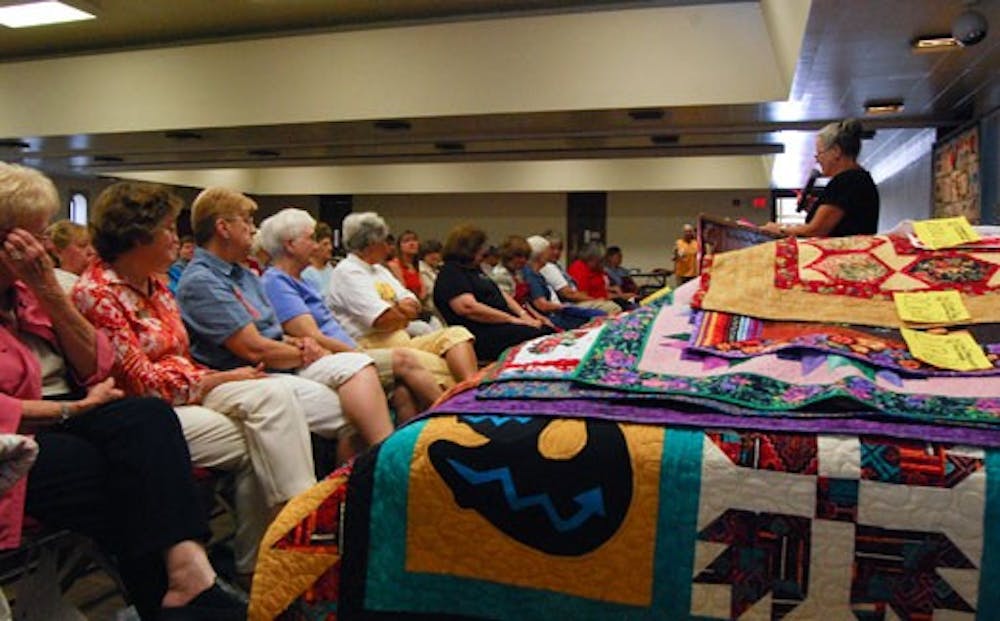 Members of the New Mexico Quilters' Association discuss upcoming events Monday at UNM Continuing Education.