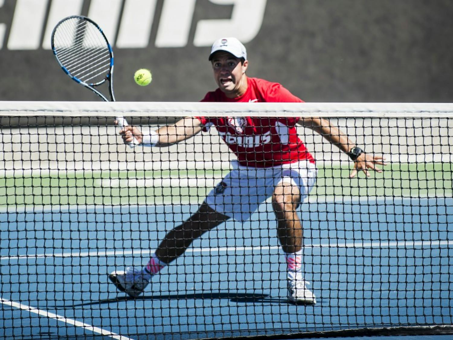 Redshirt junior Rodolfo Jauregui rushes down to the net to return the ball to a Boise State player Sunday afternoon at the McKinnon Family Tennis Stadium.