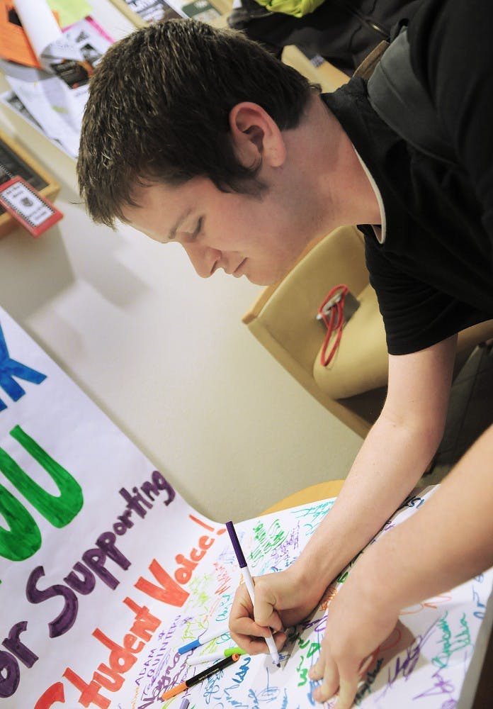 	Senior Devin Most signs a thank you letter to UNM President David Schmidly in the SUB on Thursday. PIRG was circulating the letter after the administration rescinded its recommendation to cut the group and several others instead of raising student fees.