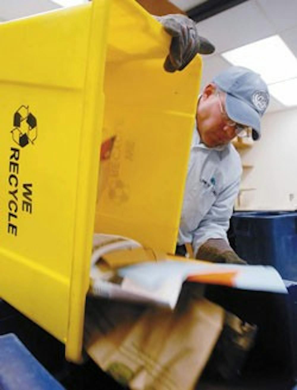 UNM recycling coordinator Dean Jojola empties a recycling bin into a container with other recyclables Tuesday in Castetter Hall. 