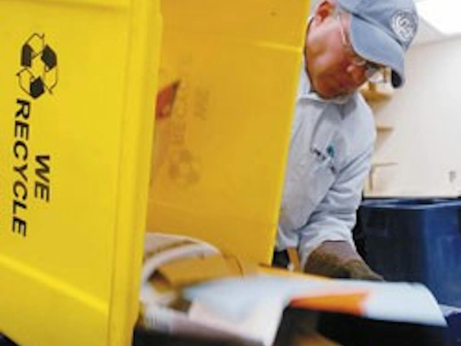 UNM recycling coordinator Dean Jojola empties a recycling bin into a container with other recyclables Tuesday in Castetter Hall.