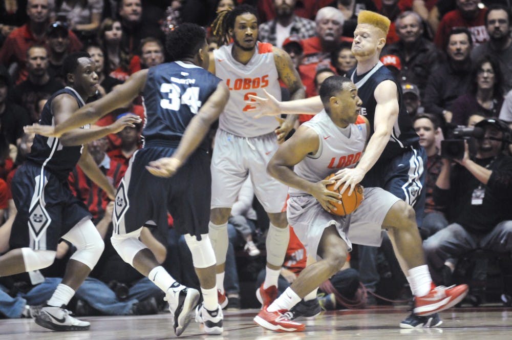 New Mexico guard Tim Jacobs, right, is defended by Utah State forward Sean Harris during Saturdays game at WisePies Arena. The Lobos fell to the Aggies 63-60.