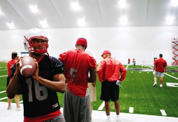 UNM quarterback Victor James warms up on the sidelines during practice Friday in the indoor practice facility. 