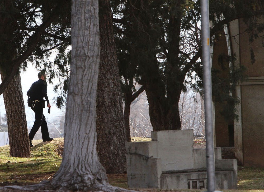 	A UNMPD officer holds a gun at his side in pursuit of a reported gunman near Hodgin Hall Monday afternoon. Witnesses told officers that they saw a man pressing a gun to the back of a young boy’s head near the Communication and Journalism building. 